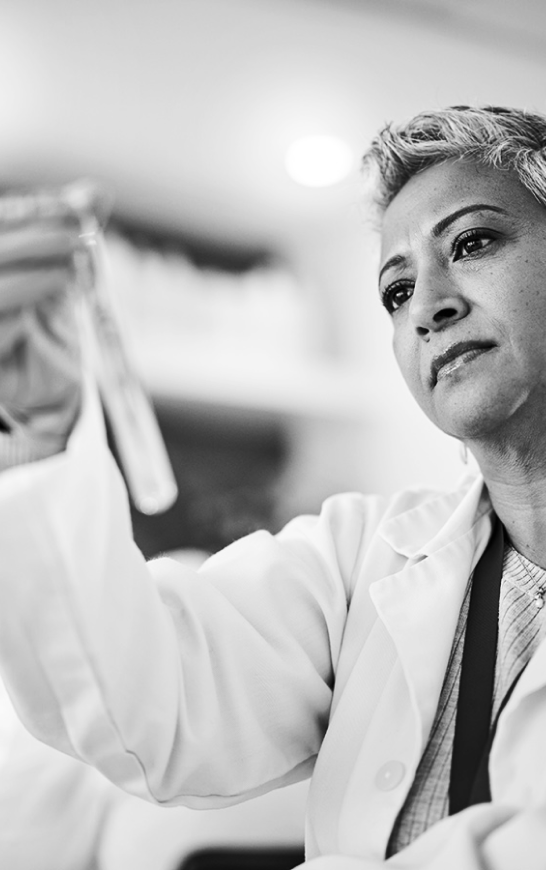 Medical professional in laboratory holding a test tube.