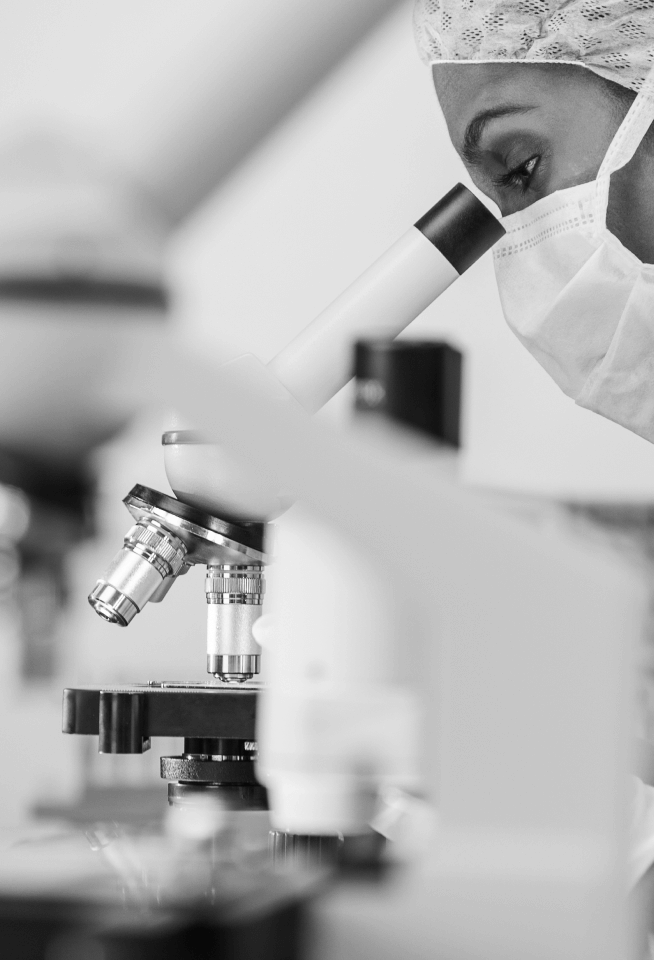 Medical researcher looking through microscope.