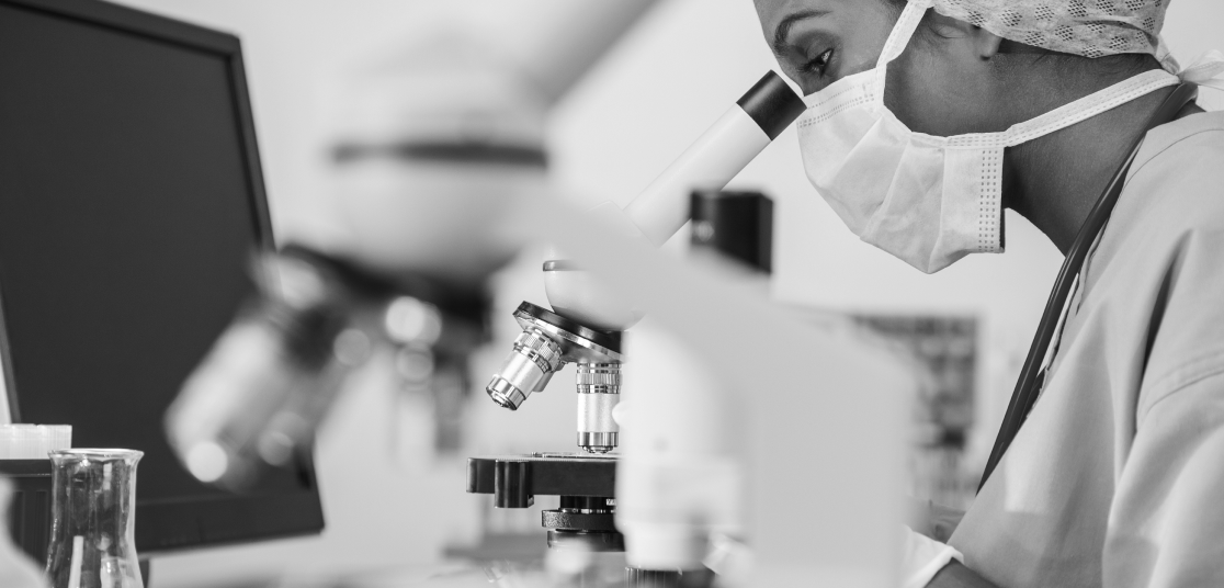 Medical researcher looking through microscope.