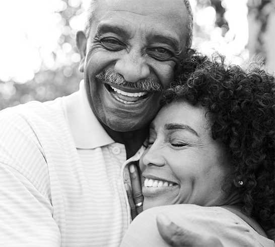 Couple hugging and smiling.